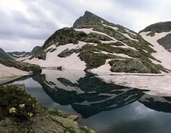 Imagen espejo de los picos de montaña están cubiertos de glaciares en el lago —  Fotos de Stock