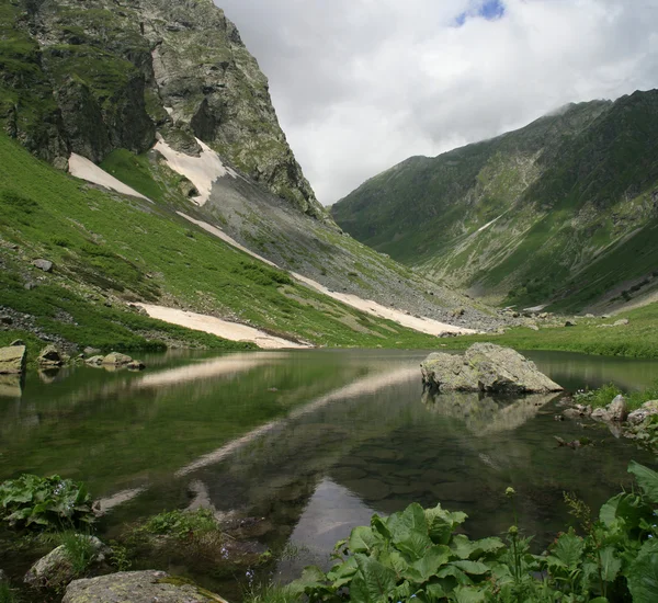 Lake in de bergen op een bewolkte dag. reflectie in water — Stockfoto