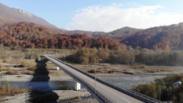 Vista aérea del viaducto de la autopista. Vuelo en avión no tripulado sobre la autopista contra el fondo de las montañas. Tráfico de coches en la carretera puente. Vuela por encima de los vehículos conduciendo. 4k — Vídeos de Stock