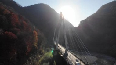 Kabloyla yapılan hava görüntüsü Sochi, Krasnaya polyana, Rusya 'da köprü olarak kaldı. Köprü üzerinde destansı bir uçuş. Yolda küçük bir trafik vardı. 4k.