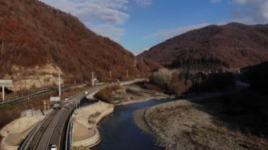 Fantastik Kanyon Dağı Nehri 'nin üzerinden insansız hava aracı uçuşu dramatik sonbahar manzarası Orange Hills Çam Ağacı Ormanları. 4k