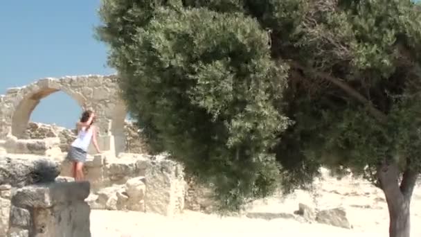 Hübsche junge Frau spaziert in der Nähe der Ruinen — Stockvideo