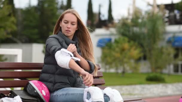 Menina coloca guardas para patinação em rolo — Vídeo de Stock