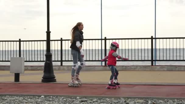 Мама и дочь учатся кататься на роликах — стоковое видео