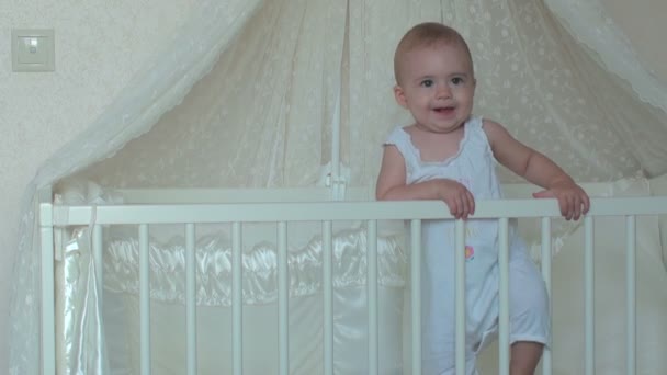 Χαριτωμένο μικρό μωρό κορίτσι στέκεται στο κρεβάτι. FullHD βίντεο — Αρχείο Βίντεο