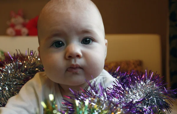 Mycket liten söt flicka i sängen med en jul krans — Stockfoto