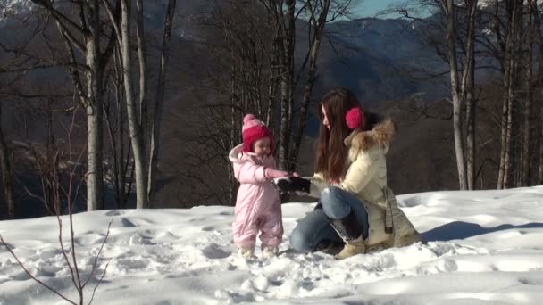 Щаслива мати грає в сніжки зі своєю дочкою — стокове відео
