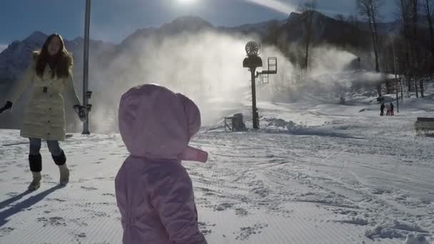 Criança pequena andando com sua mãe nas montanhas em um dia ensolarado no inverno — Vídeo de Stock