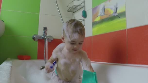 Cute one year old girl taking a relaxing bath with foam — Stock Video