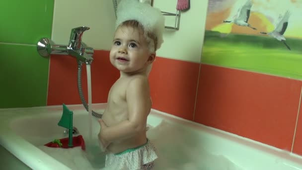 Lilla barnet ett år ålder skrattar och ler i badet — Stockvideo