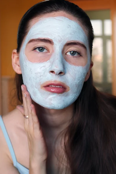 Mulher fazendo máscara cosmética em seu rosto — Fotografia de Stock