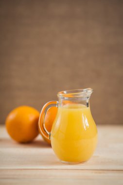 Ahşap arka plan üzerine açık kavanoza portakal suyu