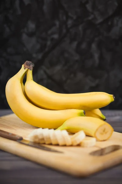 ahşap tahta üzerinde bir bıçakla dilimlenmiş muz