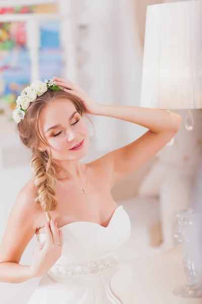 Gyönyörű menyasszony szőke lány esküvői ruha viselése a tükör előtt — Stock Fotó