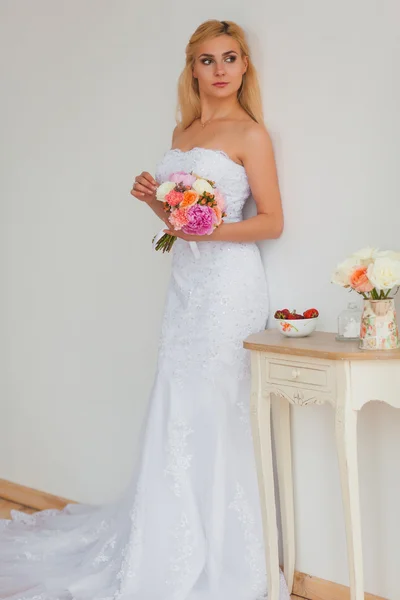 Retrato de una hermosa novia rubia con ramo de flores en una luz interior, concepto de boda —  Fotos de Stock