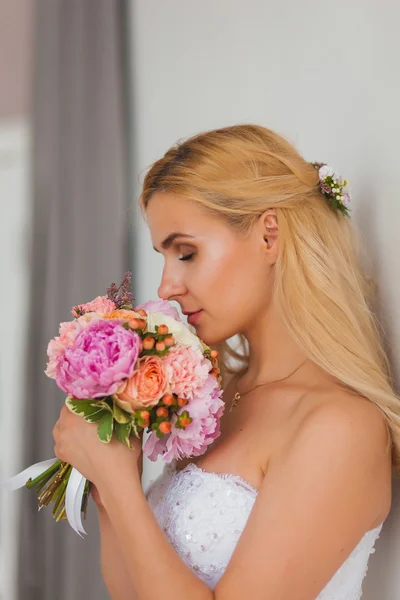 Retrato de uma bela noiva loira com buquê em uma luz interior, conceito de casamento — Fotografia de Stock