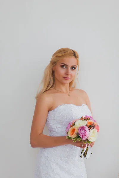 Retrato de uma bela noiva loira com buquê em uma luz interior, conceito de casamento — Fotografia de Stock