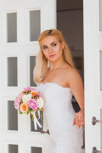 Retrato de uma bela noiva loira com buquê em uma luz interior, conceito de casamento — Fotografia de Stock