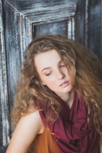 Genç kıvırcık kadın bir eşarp ve kot pantolon