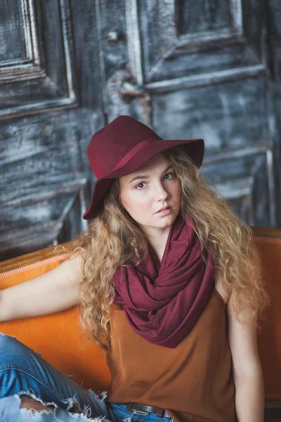 모자와 청바지에서 아름 다운 곱슬 머리 소녀 — 스톡 사진