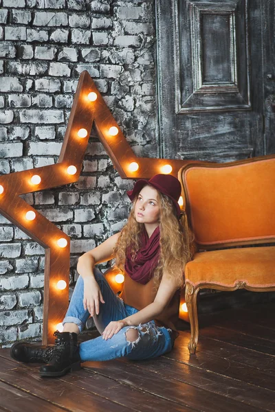 Belle fille aux cheveux bouclés en chapeau et jeans — Photo