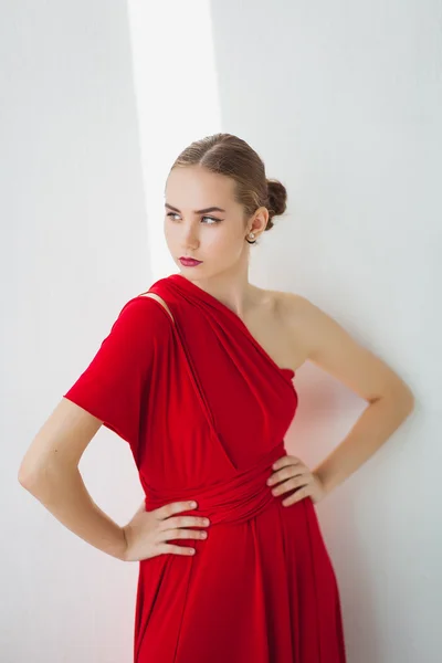 Chica joven en un vestido rojo sobre un fondo blanco —  Fotos de Stock