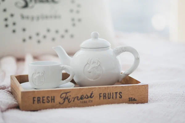 Beyaz çaydanlık ve bardak bir ahşap tepsi
