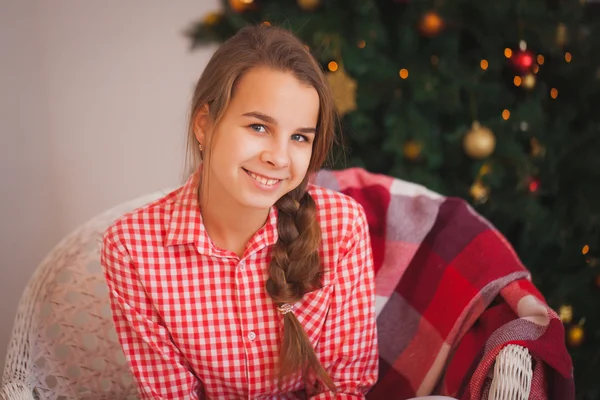 Chica adolescente con coletas en una camisa a cuadros roja en decoraciones de Navidad —  Fotos de Stock