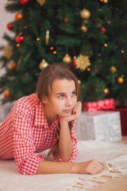 tatil, hediyeler, Noel, çocukluk ve insan kavramı - oyuncak ayı ile santa yardımcı şapkalı kız ışık arka plan üzerinde gülümsüyor.