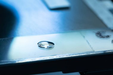 Kaydırağın üzerindeki su damlası mikroskopla incelenmeye hazır. Nehir suyunun mikrobiyal yükü, mavi atmosfer analizi.