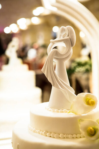 cake with three floors above the statues of the couple