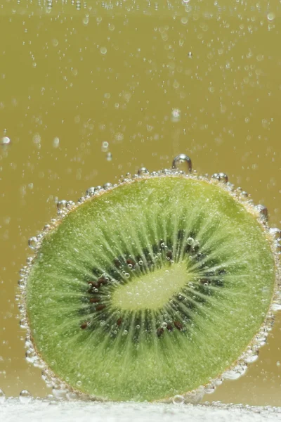 Fresh kiwi fruits with bubbles in the water — Stock Photo, Image