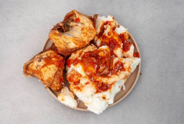 Gri bir yüzeyde Pap ve tavuk parçalarının üstten aşağı görüntüsü