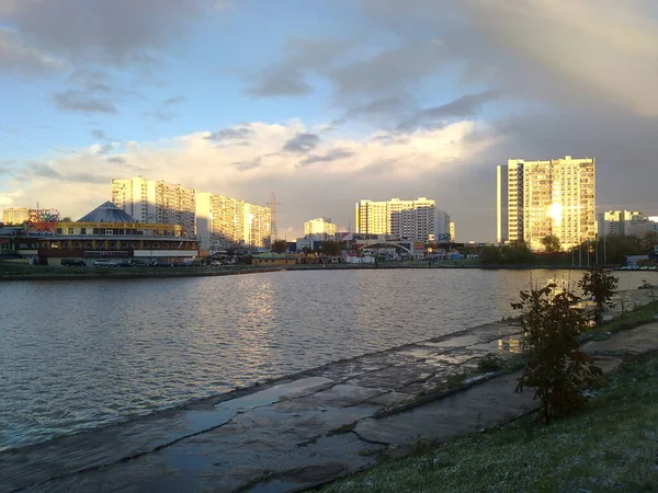 空と日当たりの良いまたは曇りのスカイラインの反射と銀行からの水の風景 — ストック写真