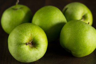 Koyu arkaplanda yeşil elmalar