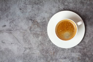 Beton arka planda bir fincan sade kahve ve teks için bir yer.