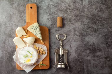 Tahta tirbuşonda çeşitli peynirler ve şarap kokuları.