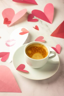 Bir fincan sade kahve ve bir sürü kağıt kalp.