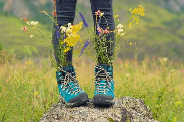 Wild flowers bouquet into the travel shoes. Freedom travel conce — Stock Photo, Image