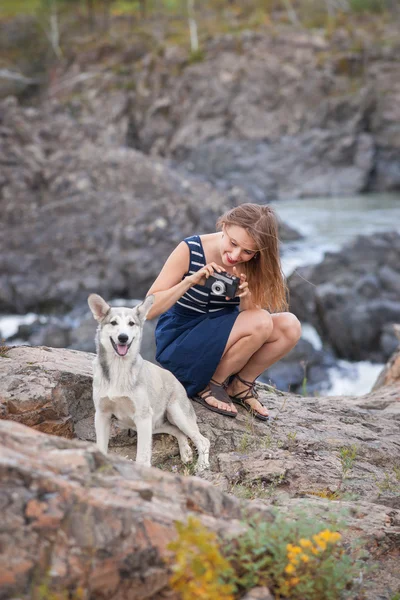 Mujer tomando fotos con su perro en el fondo de la montaña . — Foto de Stock