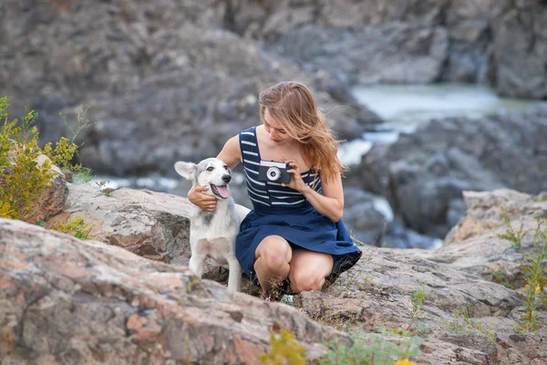 Mujer tomando fotos con su perro en el fondo de la montaña . — Foto de Stock