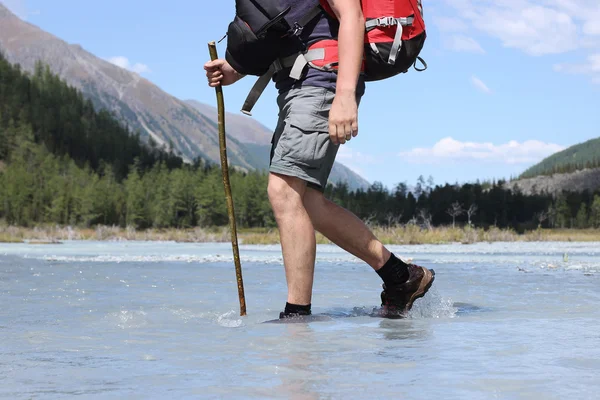 Backpacker go into the mountains. Mountain trekking. Man in harm