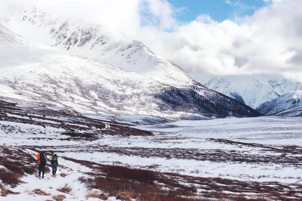 Mochileros trevelers cruzar un valle de montaña nevado. Altai. Russ. —  Fotos de Stock