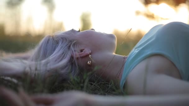Krásná dívka venku a slunce, ležící na trávě — Stock video