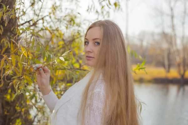 Meisje die zich voordeed op de achtergrond van de rivier in de herfst — Stockfoto