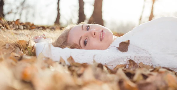 여 자가 즐기는 마른 나뭇잎에 누워 태양 — 스톡 사진