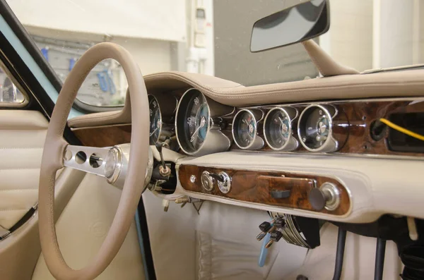 Luxe Race Retro Car Interieur met Beige afwerking. Snelheidsmeter en toerenteller op het dashboard. Auto in werkplaats — Stockfoto