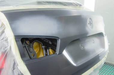 Araba boyası koruma folyosuyla kaplanmış lüks araba, profesyonel araç boyama kabininde sprey boyayla boyaya hazır ve sökülmüş. Araba Servisinde Araç Boyama İşlemi. Jpeg Resmi