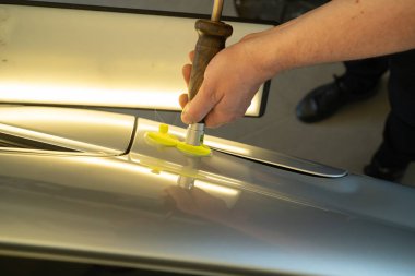 Process Of Paintless Dent Repair On Car Body. Technician s Hands With Puller Fixing Dent On Rear Car Fender. PDR Removal Course Training