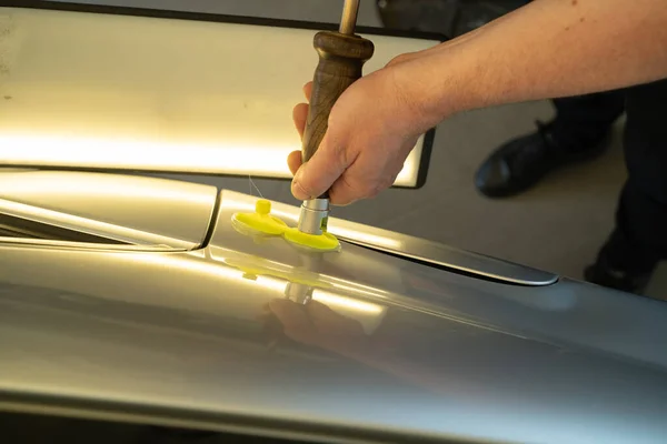Process Of Paintless Dent Repair On Car Body. Technician s Hands With Puller Fixing Dent On Rear Car Fender. PDR Removal Course Training